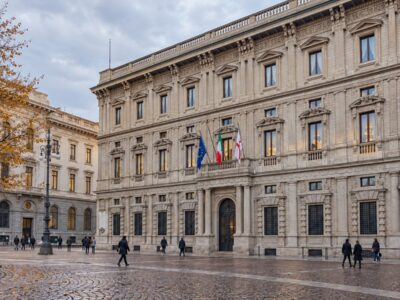 Palazzo Marino, sede del Comune di Milano, con un tram e un autobus ATM che passano in piazza della Scala