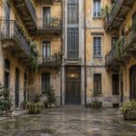 cortile di un palazzo di case popolari all'isola di milano con muri segnati da muffa e intonaco rovinato