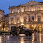 Palazzo Marino a Milano al tramonto, con un mezzo dell'esercito e due militari in piazza della Scala