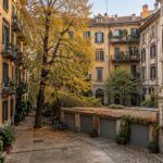 Cortile interno di un isolato storico di Milano con autorimesse e alberi, tema della variante al PGT